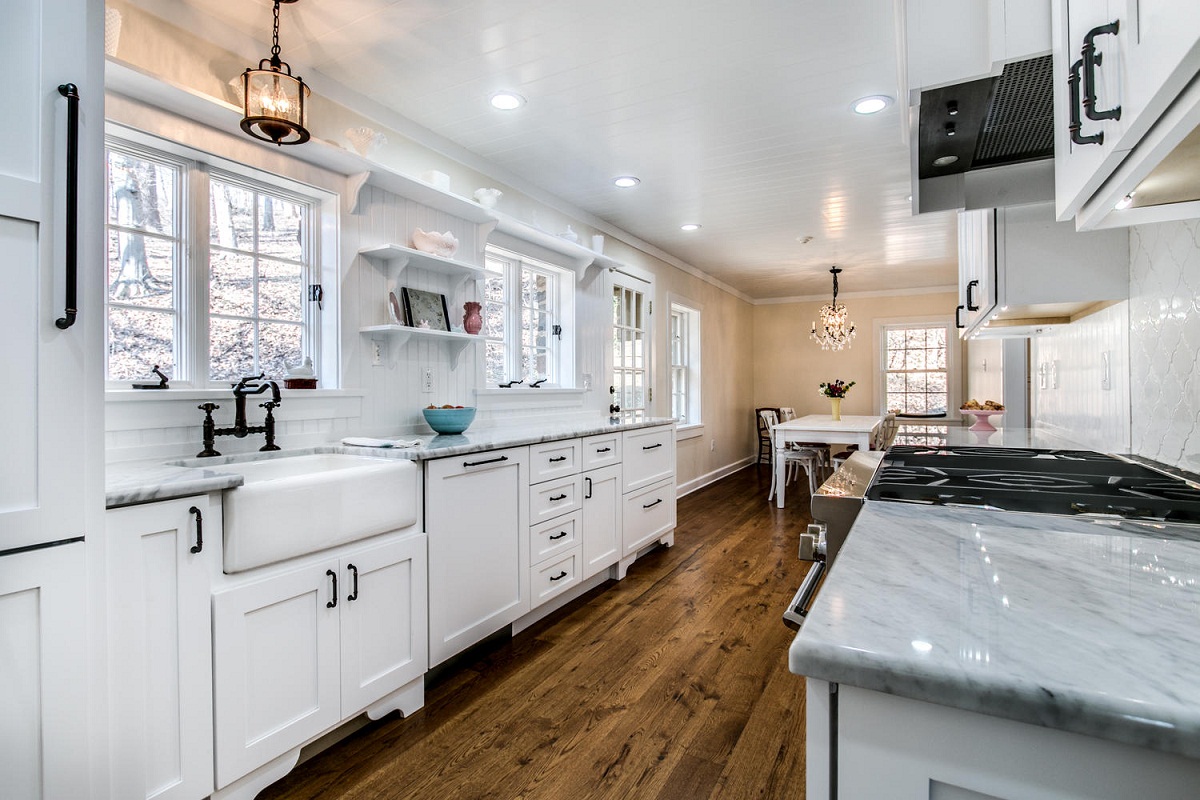 White kitchen with farmhouse sink and wood floors