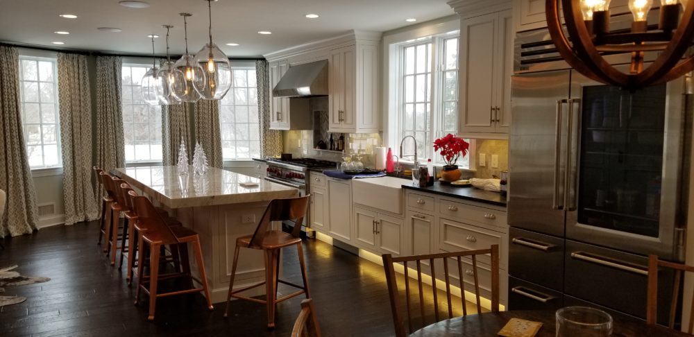 A remodeled kitchen with an island and under-furniture lighting